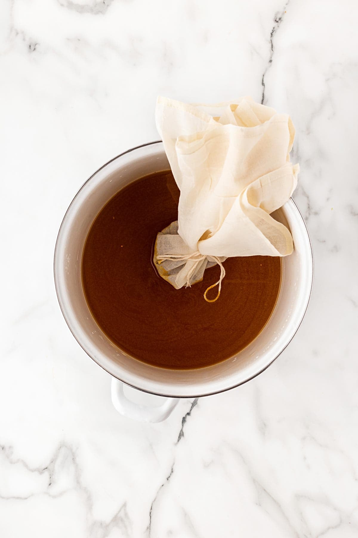 Pickling spice pouch steeping in a vinegar and sugar mixture