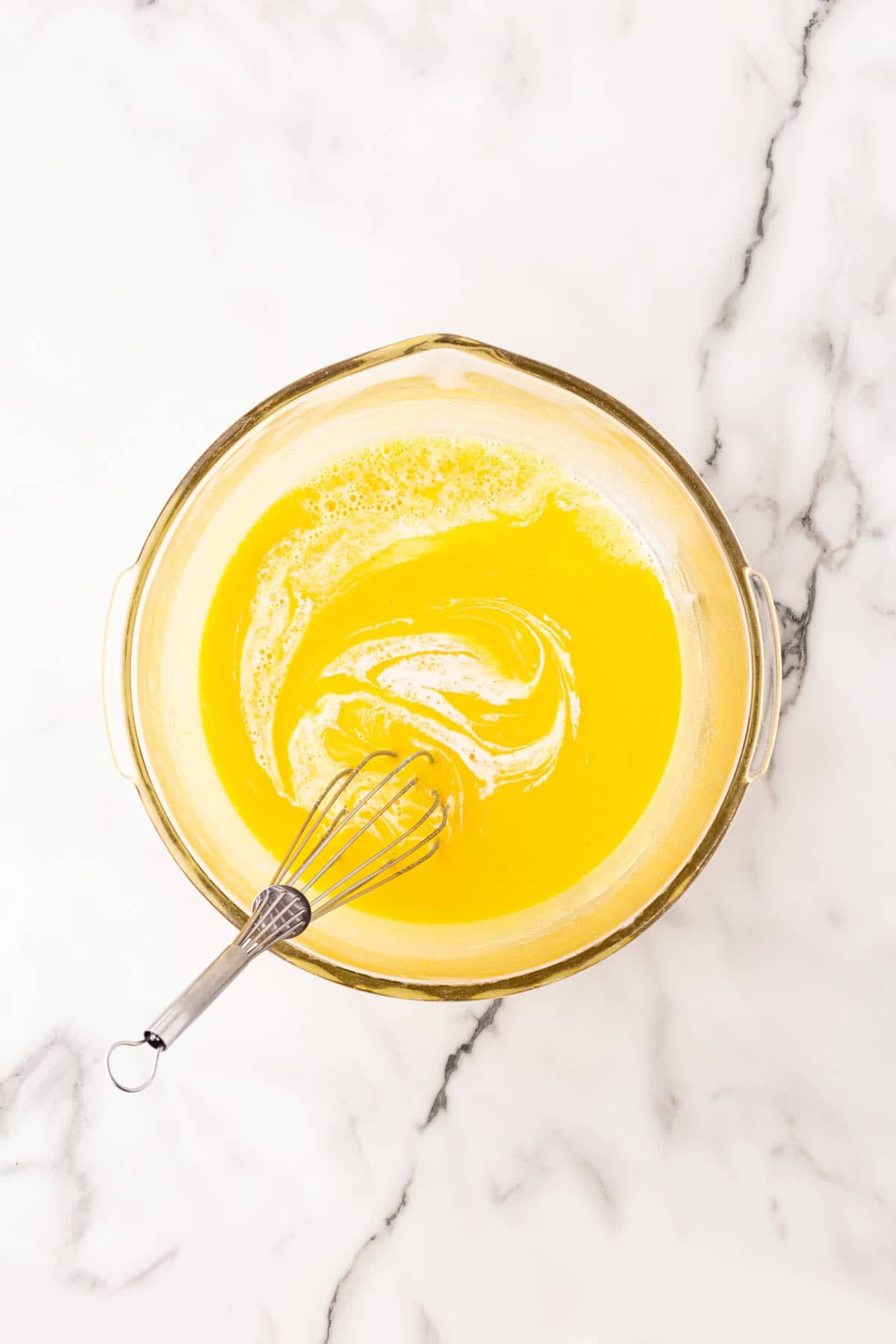 Whisking egg and sugar mixture with heavy cream mixture until smooth and combined in a glass bowl