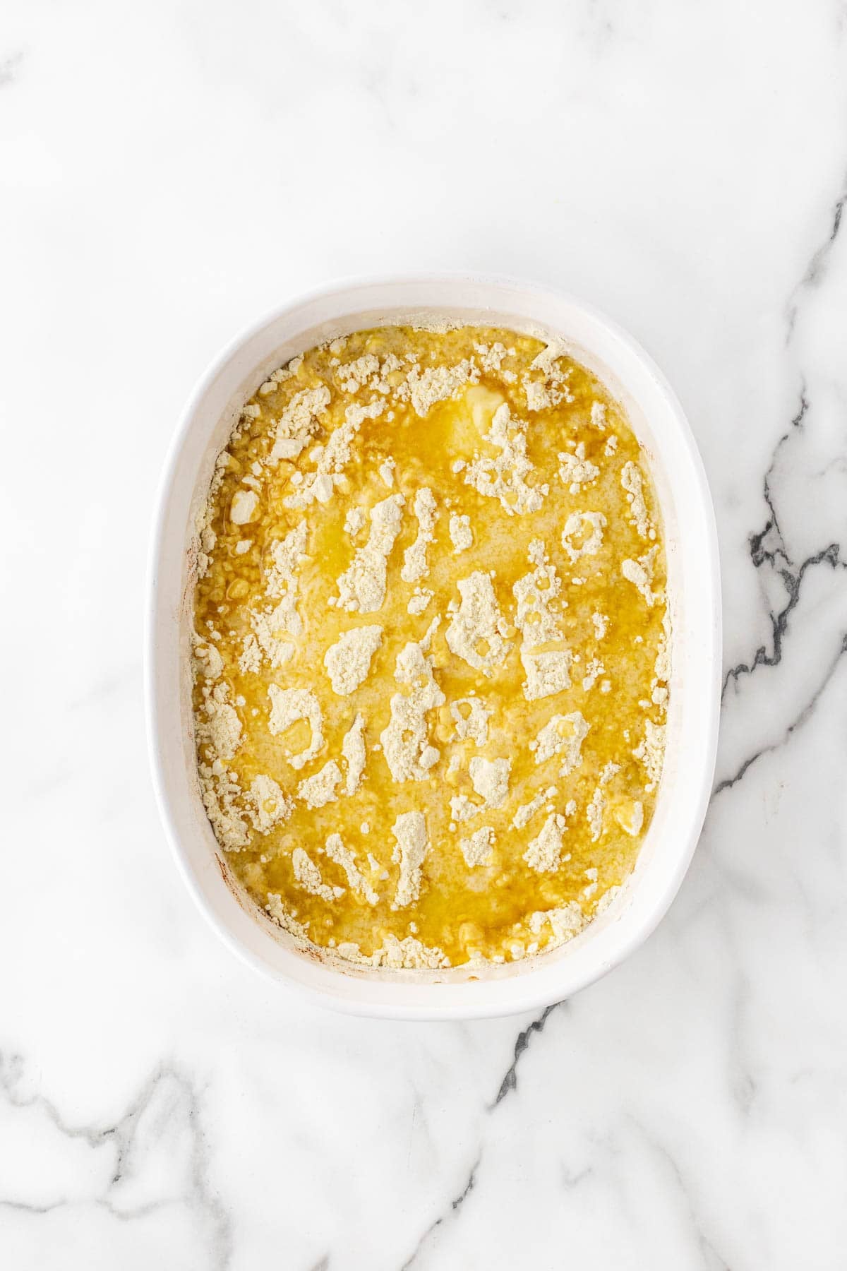 Dry yellow cake mix evenly sprinkled over the peaches, with melted butter drizzled over the cake mix
