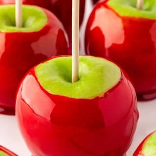 Closeup of glossy red candied apples with wooden sticks