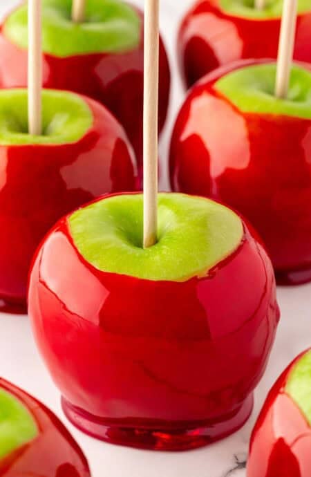 Closeup of glossy red candied apples with wooden sticks