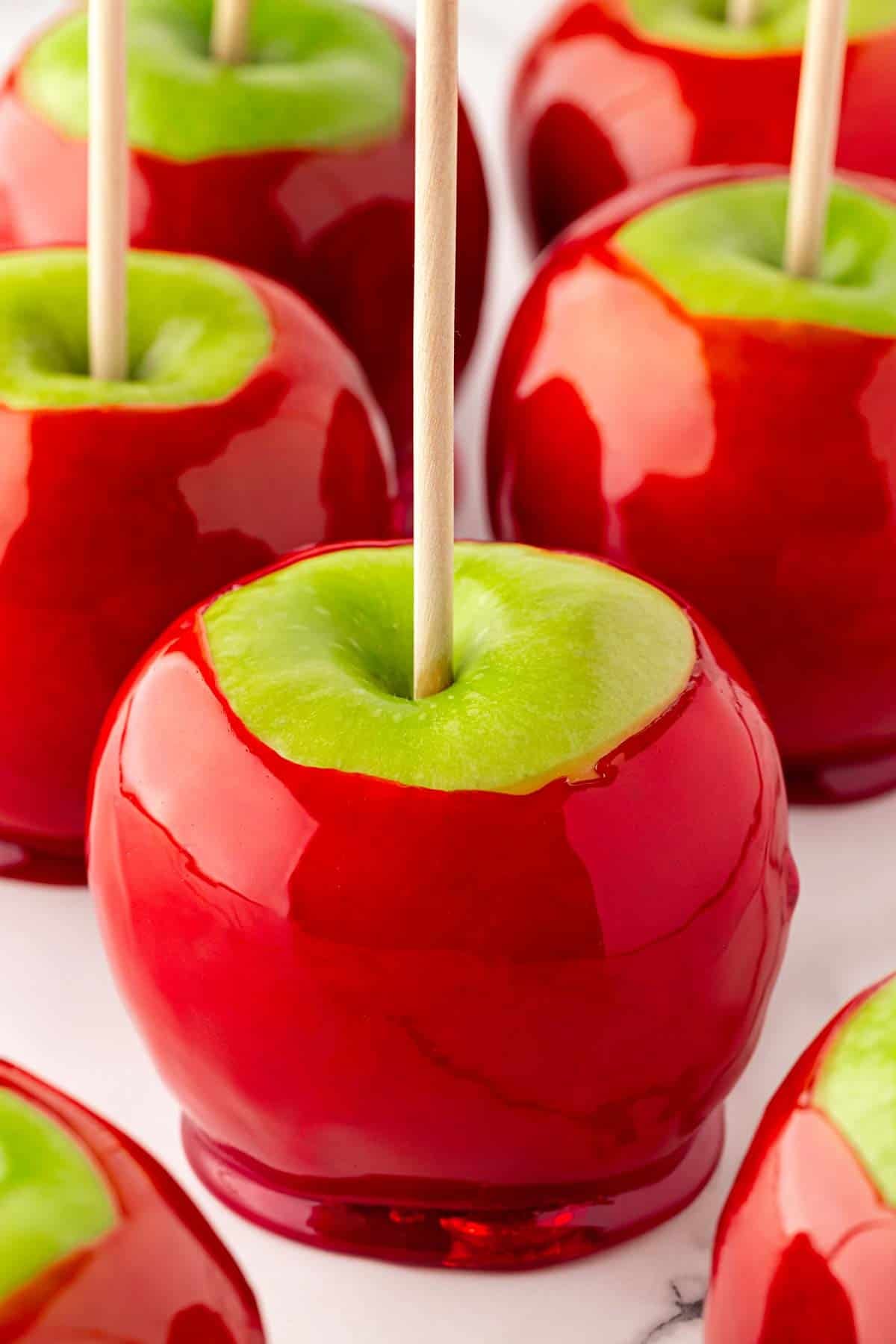 Closeup of glossy red candied apples with wooden sticks