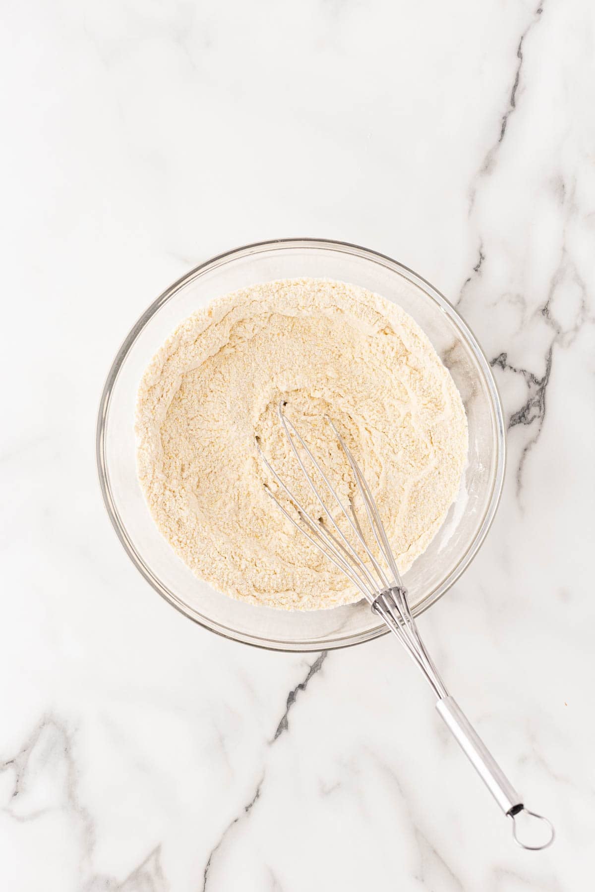 Dry ingredients whisked together in a glass mixing bowl