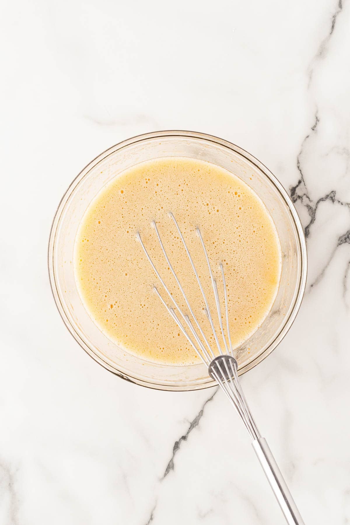 Wet ingredients whisked together in a glass mixing bowl