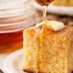 Honey drizzled over a slice of honey butter cornbread with butter