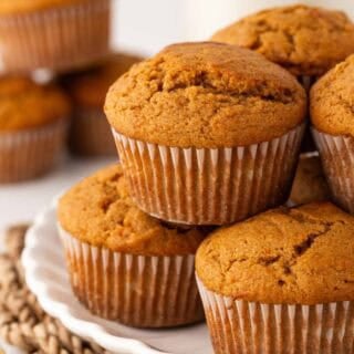 Stack of golden brown sweet potato muffins with domed, lightly cracked tops