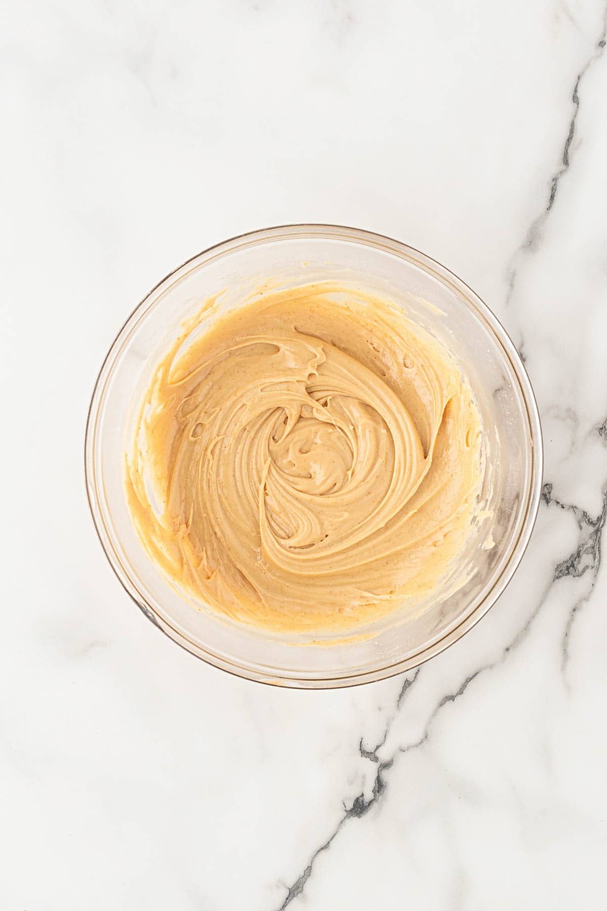 Biscoff cookie butter glaze mixed in a glass bowl