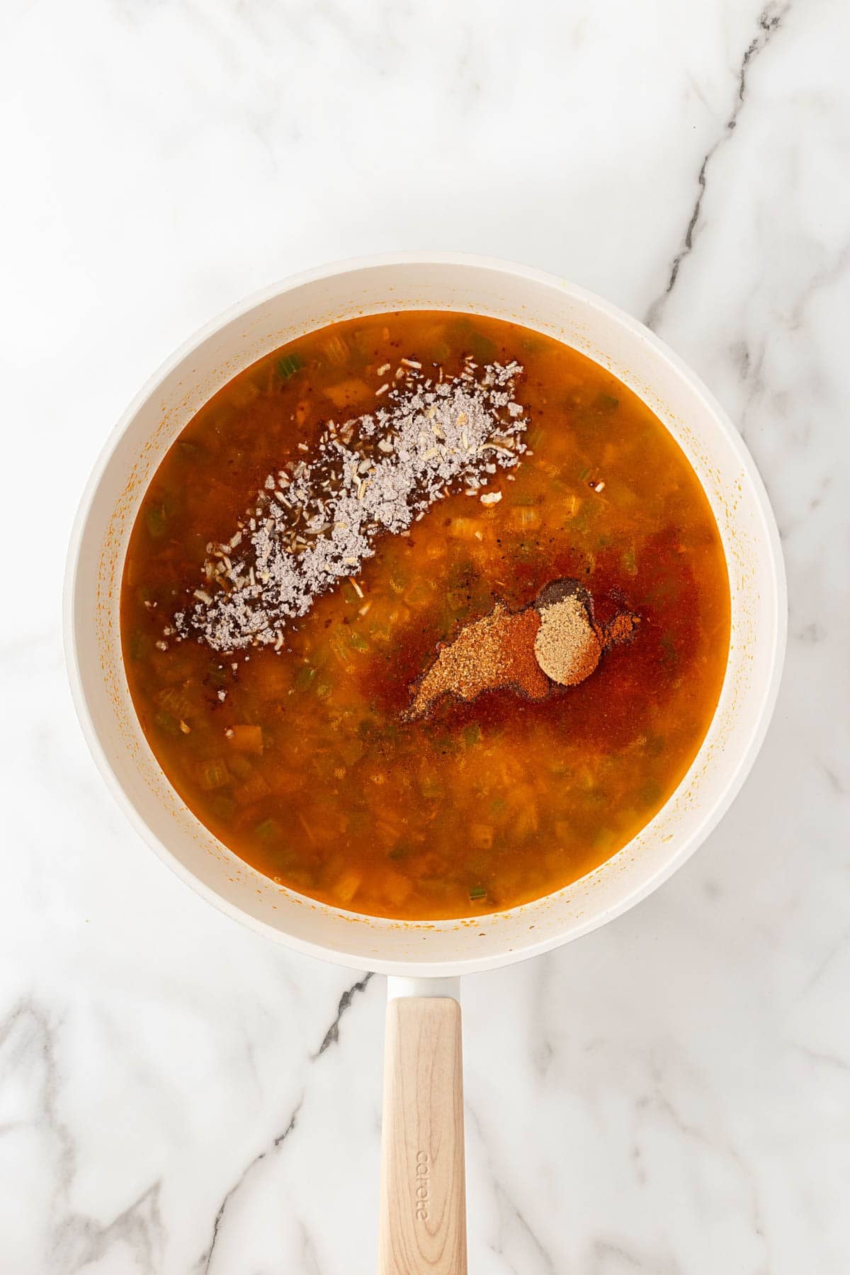 Chicken broth, soup mix, and seasonings added to the beef and vegetable mixture