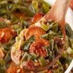 Spoonful of dirty greens with collards, andouille sausage, ground beef, and bacon