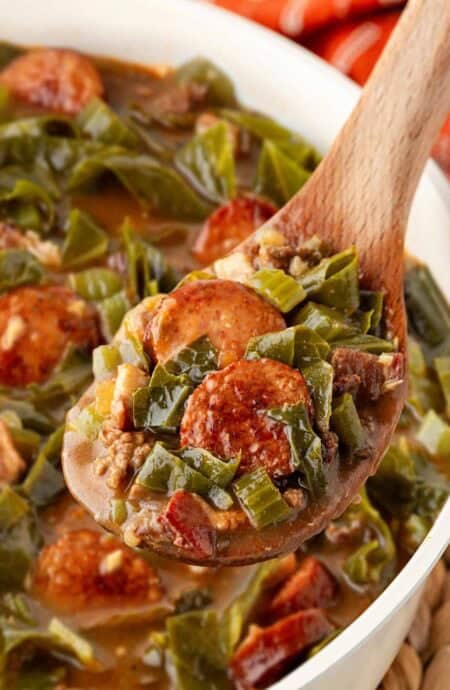 Spoonful of dirty greens with collards, andouille sausage, ground beef, and bacon