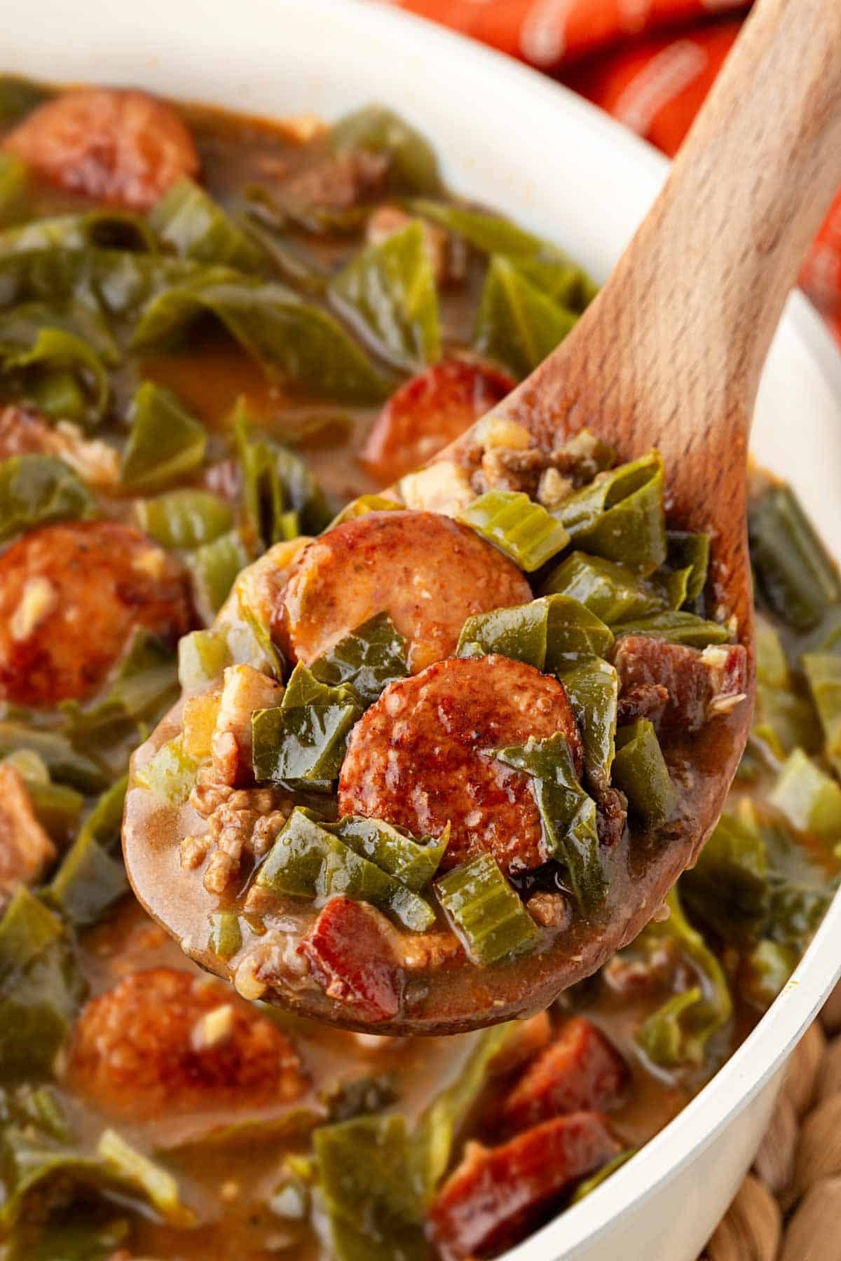 Spoonful of dirty greens with collards, andouille sausage, ground beef, and bacon