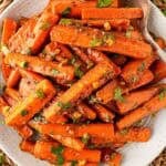 Overhead shot of glazed roasted carrots with peanut maple sauce, chopped peanuts, and fresh cilantro