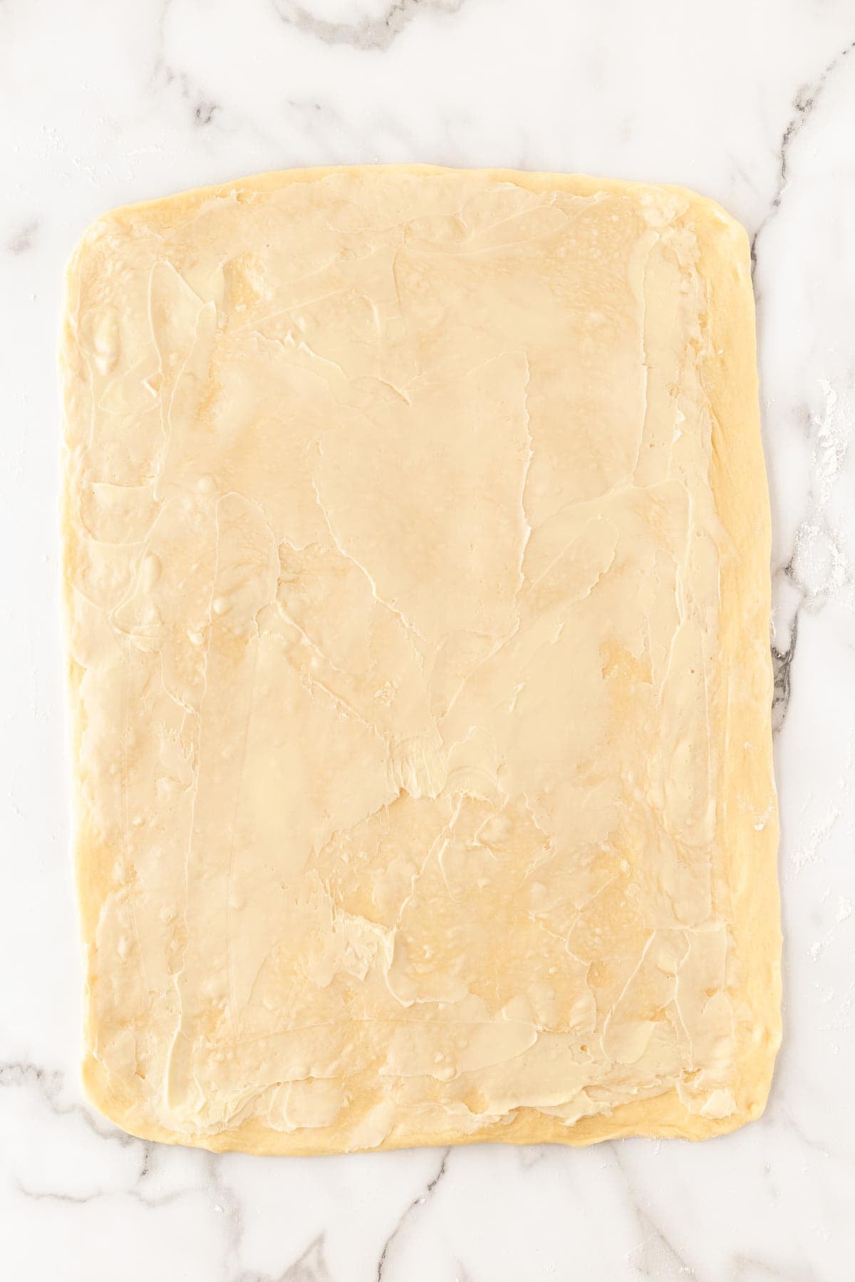 Cinnamon roll dough rolled into a rectangle and spread with softened butter