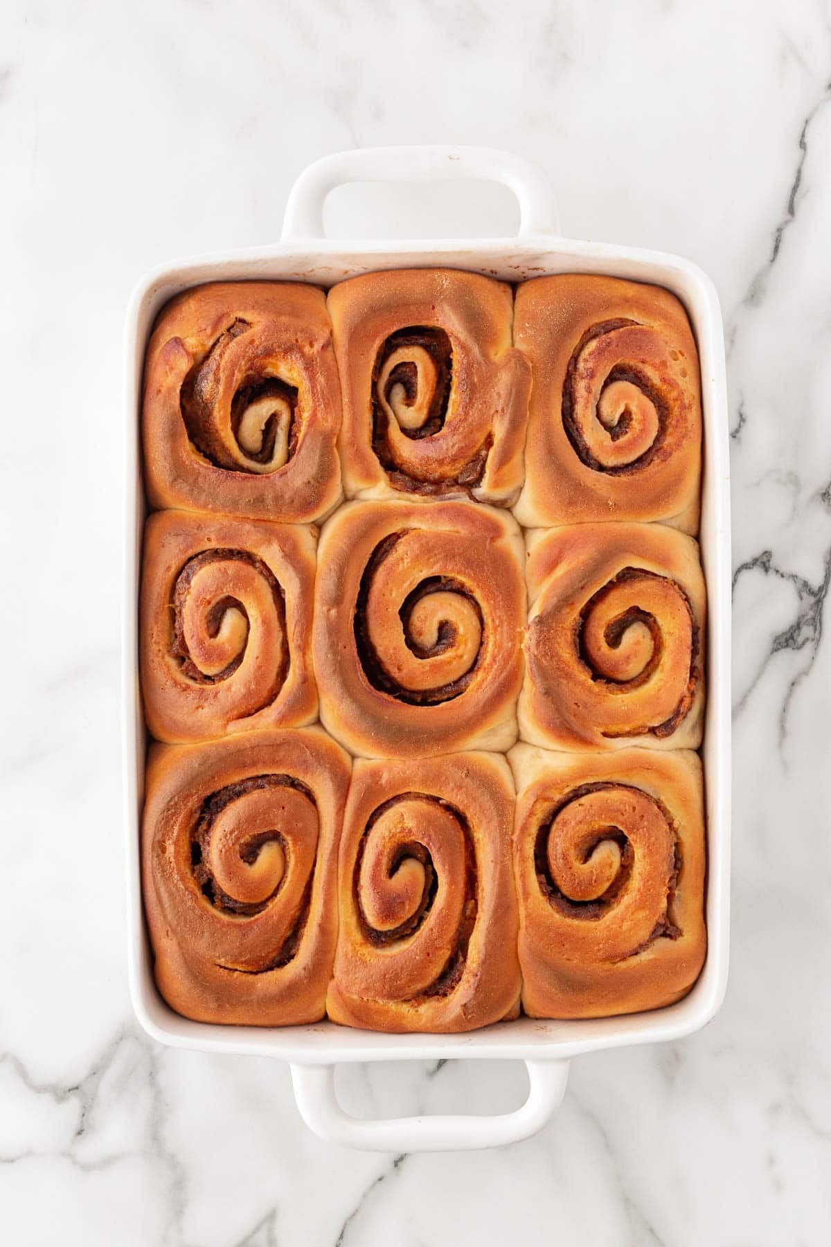 Freshly baked sweet potato pie cinnamon rolls golden brown in a baking dish